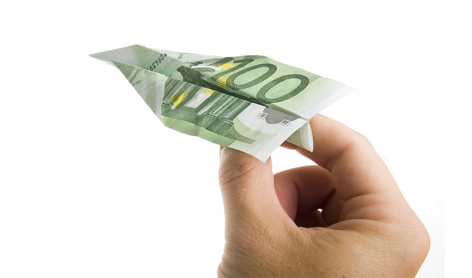 Hand die een papieren vliegtuigje gevouwen van 100 euro biljet weggooit